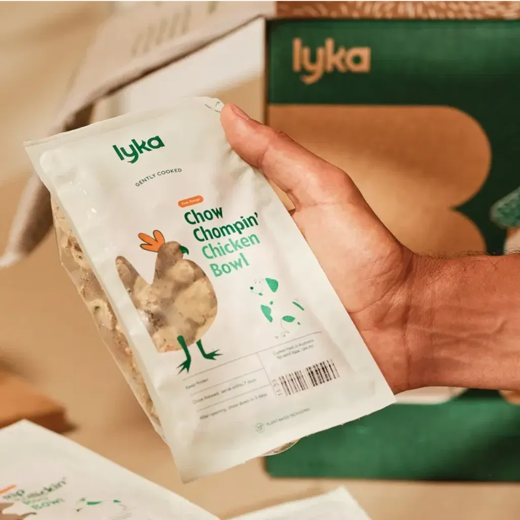 A person holding a bowl of Lyka dog food